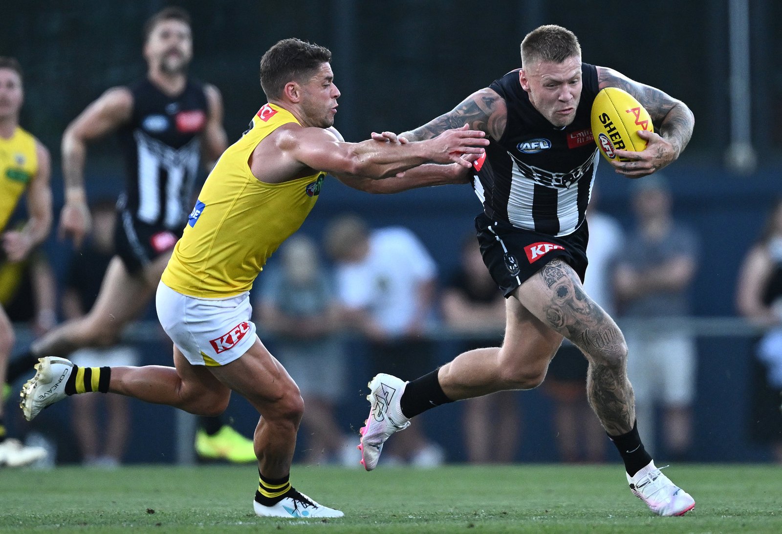 Jordan De Goey breaks away from an attempted tackle by Dion Prestia.